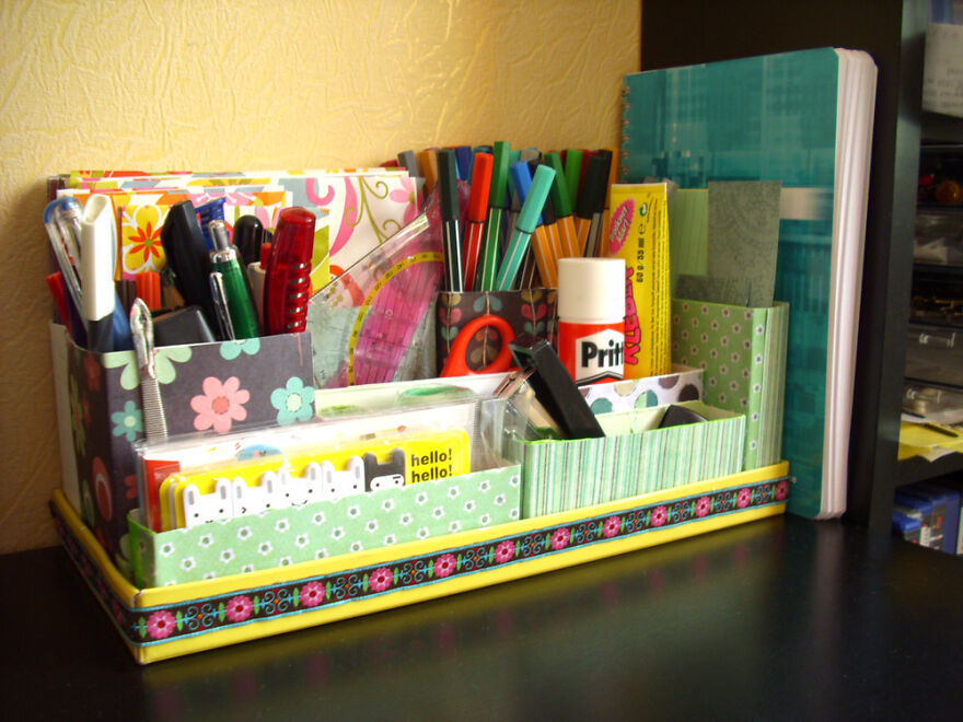 Organized desk with colorful stationery, pens, scissors, glue, and notebooks showcasing effective organization hacks for home use.