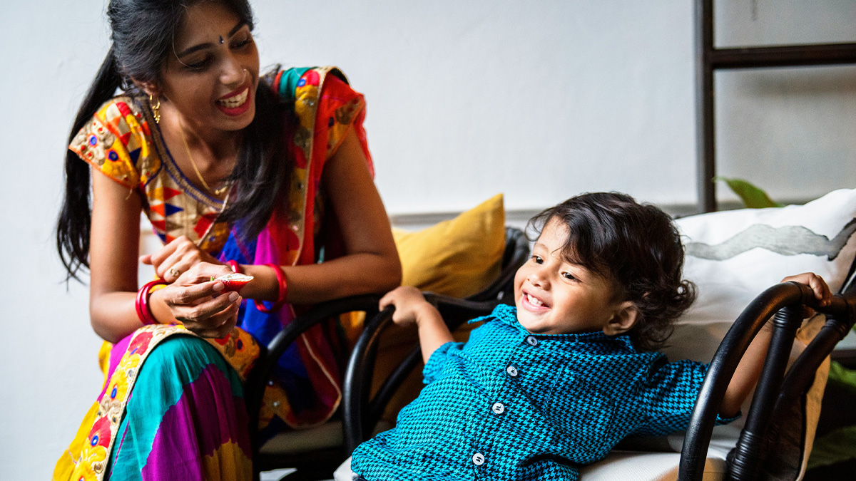 Mother smiling and playing with her toddler son at home, illustrating parents sharing baby names they regret giving.