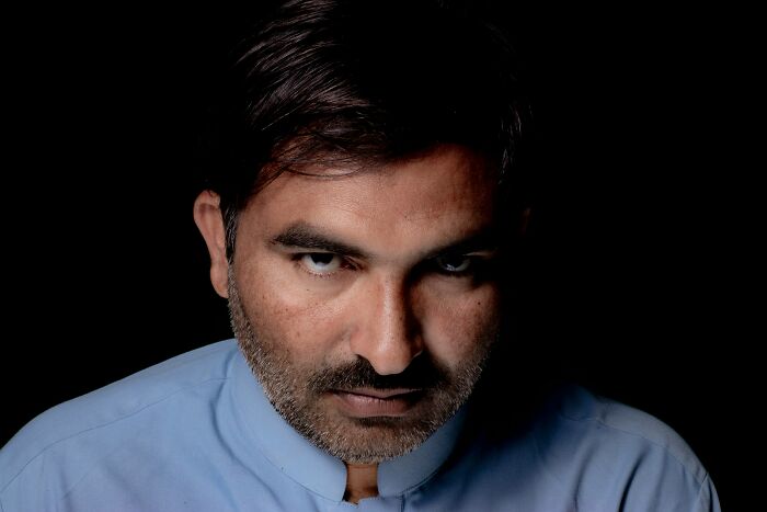 Man with intense expression in low light, representing emotional cruelty and relationship distress themes. Man with intense expression in low light, representing emotional cruelty and relationship distress themes.