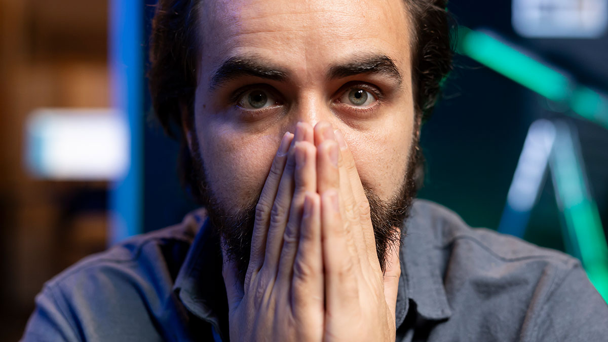 Man with anxious expression covering mouth with hands, reflecting on worst crimes that happened in hometowns.