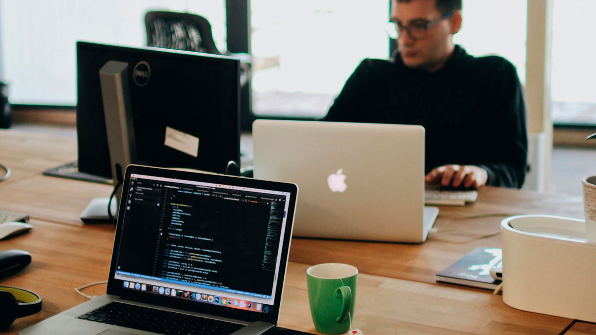 Man working on laptop in office setting with multiple screens, highlighting signs an industry professional isnu2019t trustworthy