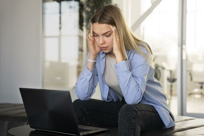 Young woman stressed while using laptop, representing boss wife claim affair involving an innocent worker concept. Young woman stressed while using laptop, representing boss wife claim affair involving an innocent worker concept.
