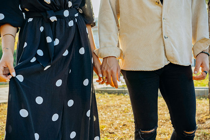 Couple holding hands outdoors with tension, illustrating man ruins marriage by stealing wife's tea set and giving it away. Couple holding hands outdoors with tension, illustrating man ruins marriage by stealing wife's tea set and giving it away.