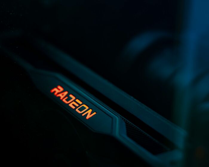 Close-up of a Radeon graphics card illuminated in orange, symbolizing intense power and long-held grudges.