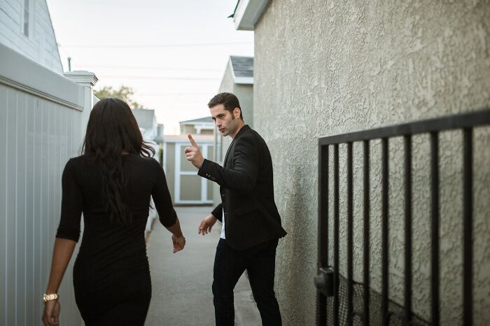 Man and woman in a tense conversation outside a building, illustrating signs someone is having an affair.