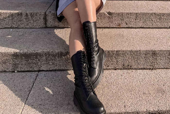 Woman wearing black leather boots sitting on stone steps in outdoor setting showing grandma’s shoes. Woman wearing black leather boots sitting on stone steps in outdoor setting showing grandma’s shoes.