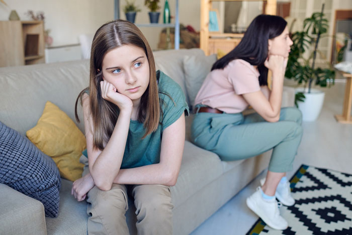 Two women sitting on a couch looking upset, illustrating conflict over grandma’s leather shoes and vegan sister wearing them. Two women sitting on a couch looking upset, illustrating conflict over grandma’s leather shoes and vegan sister wearing them.