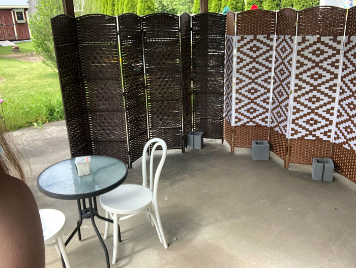 Outdoor patio with white chairs and a privacy sheet used by mom to block talkative neighbors.