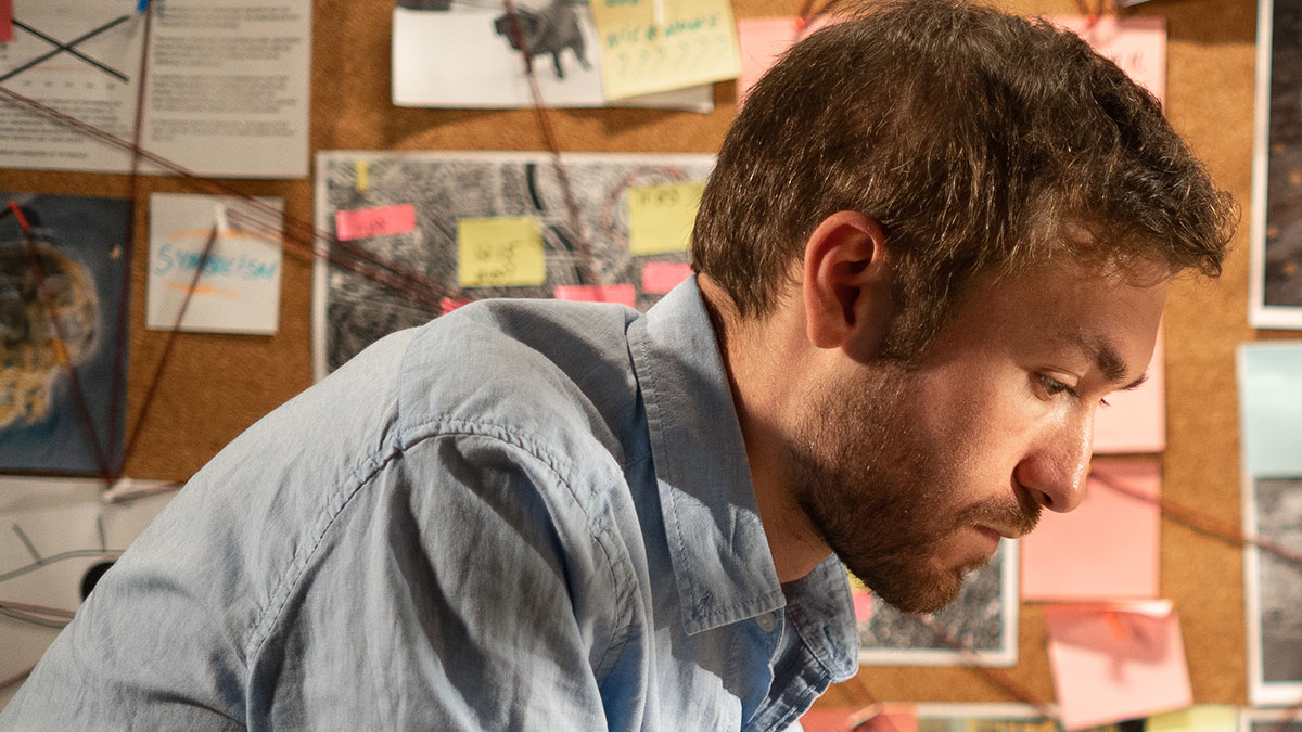 Private investigator analyzing evidence on a corkboard, focused on catching cheaters in an investigation setting.