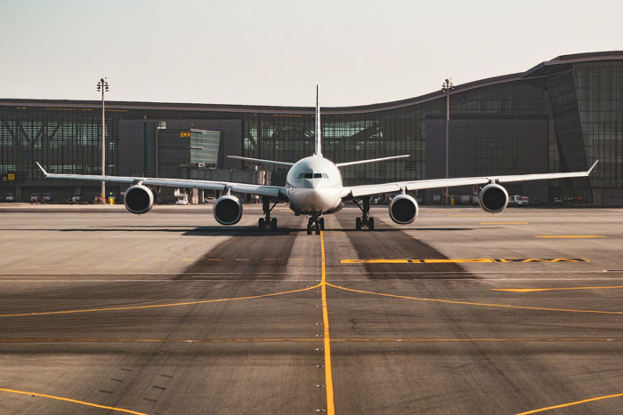 Commercial airplane taxiing on runway at airport terminal, illustrating rude family trying to bully lady from plane seat. Commercial airplane taxiing on runway at airport terminal, illustrating rude family trying to bully lady from plane seat.