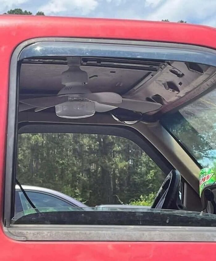 Ceiling fan installed inside a red vehicle cabin, creating an out of context and humorous occult-themed scene.
