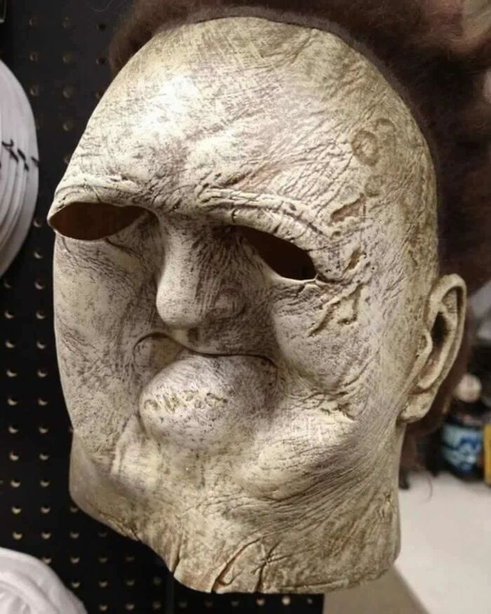 Close-up of an aged, textured occult mask with distorted features, highlighting eerie and out of context details.