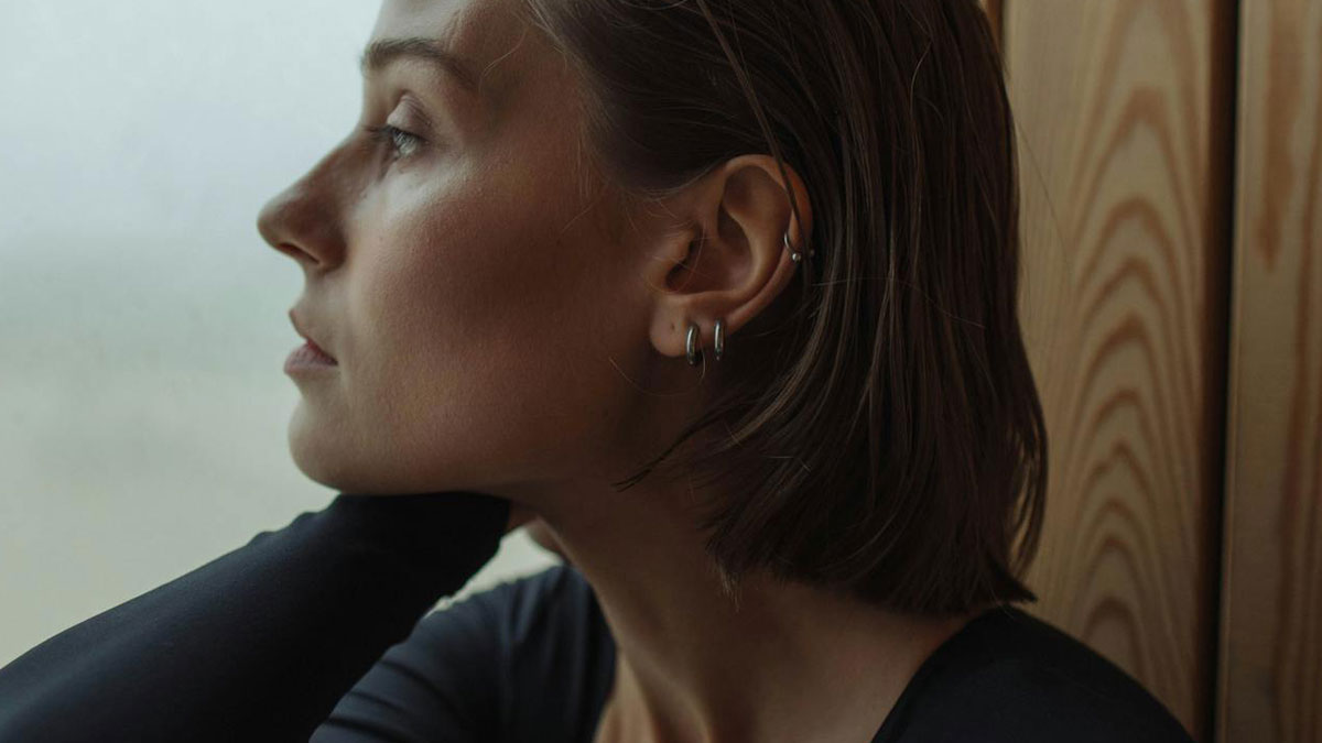 Side profile of a woman looking pensive, reflecting on how spouses changed after the wedding and ignored red flags.