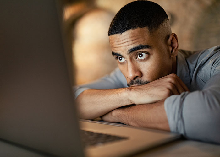 Employee looking concerned and thoughtful while resting arms on desk, contemplating exposing management and HR issues. Employee looking concerned and thoughtful while resting arms on desk, contemplating exposing management and HR issues.