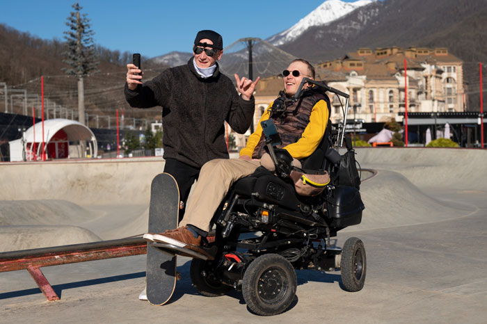 Two brothers enjoying skate park outdoors, one using wheelchair, illustrating challenges of refuse living with disabled sibling. Two brothers enjoying skate park outdoors, one using wheelchair, illustrating challenges of refuse living with disabled sibling.