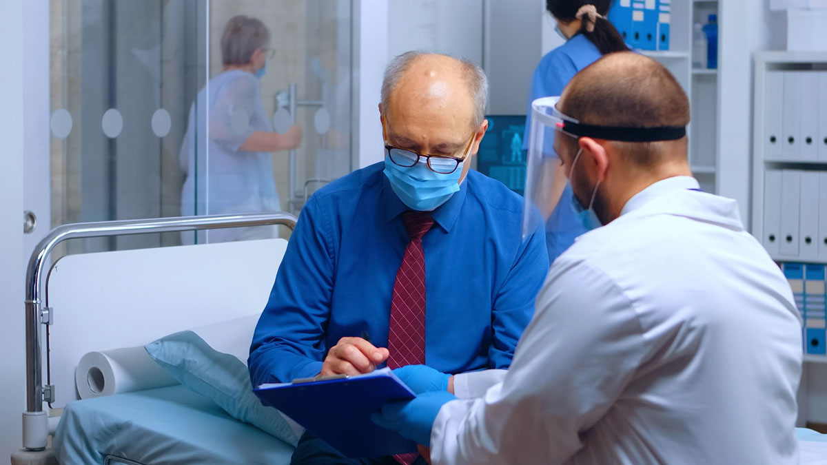 Elderly patient in hospital consulting doctor about refusing to donate liver during a medical discussion session.