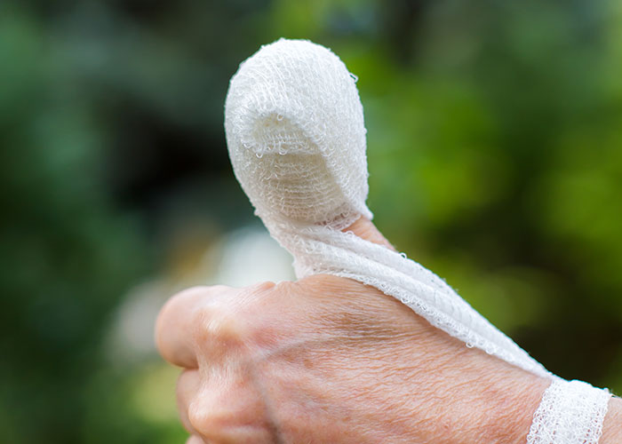 Thumb wrapped in gauze after injury, highlighting ridiculous reasons people ended up in the emergency room.