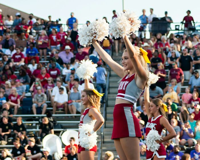 Cheerleaders performing at a school event with a large crowd, illustrating popular kids in school activities.