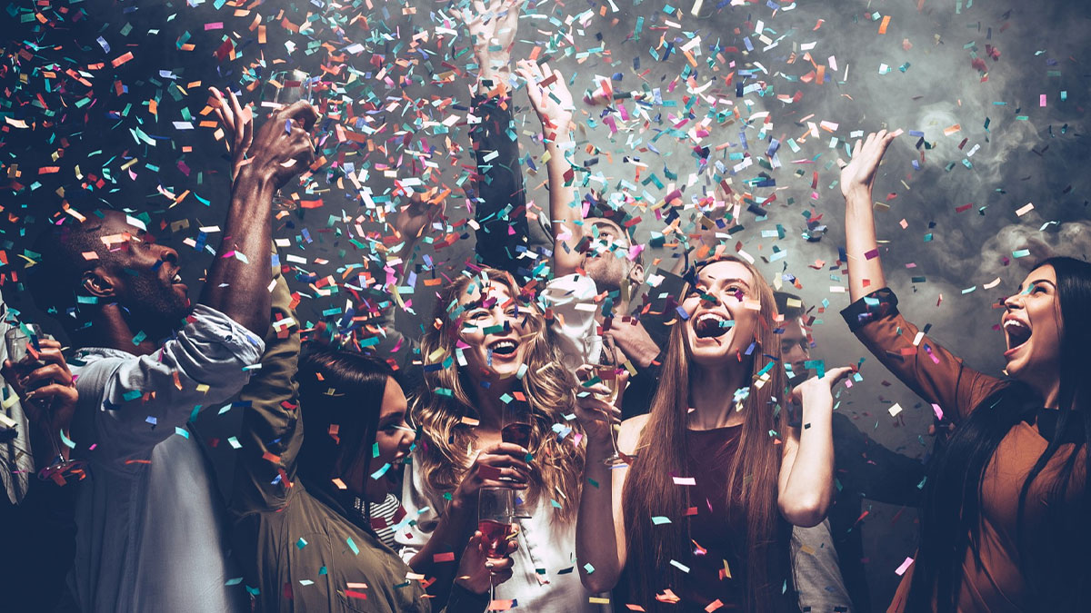 Group of diverse people celebrating with confetti and drinks, symbolizing shocking and dark secrets revealed.