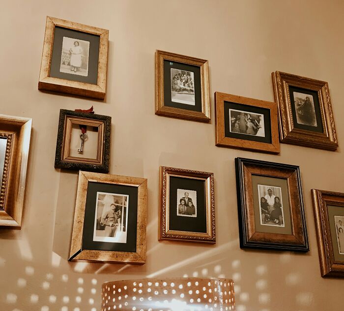Vintage family photos in ornate frames on a wall, evoking memories linked to patients with dementia and unfiltered moments.