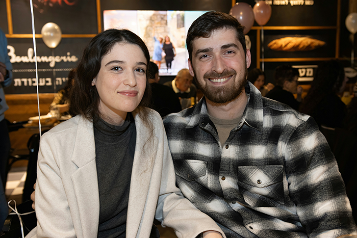 Couple smiling together at an indoor event, illustrating a moment related to a proposal with a twist about open marriage. Couple smiling together at an indoor event, illustrating a moment related to a proposal with a twist about open marriage.