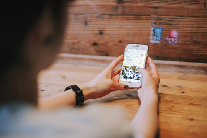 Person holding a smartphone checking Instagram, illustrating sibling blocked on social media and family tension.