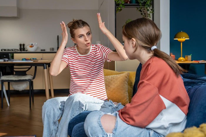 Teen and golden child cousin in a heated argument on a couch, showing frustration during a celebration at home. Teen and golden child cousin in a heated argument on a couch, showing frustration during a celebration at home.
