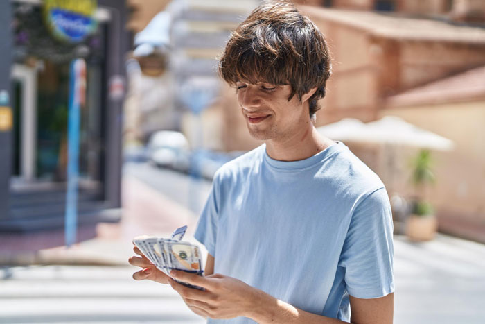 Young man mooching off parents counting cash outdoors, representing 20YO stealing 3K and getting kicked out. Young man mooching off parents counting cash outdoors, representing 20YO stealing 3K and getting kicked out.