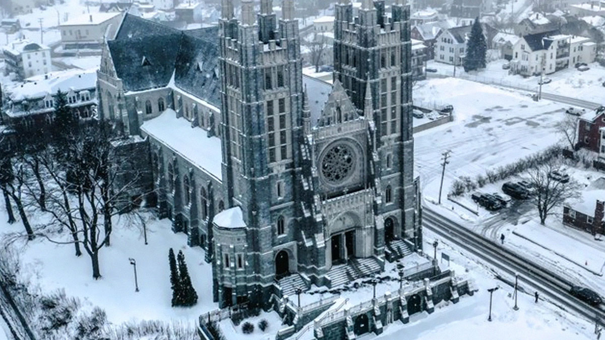 Aerial view of a beautiful and striking church covered in snow in a US town during winter.