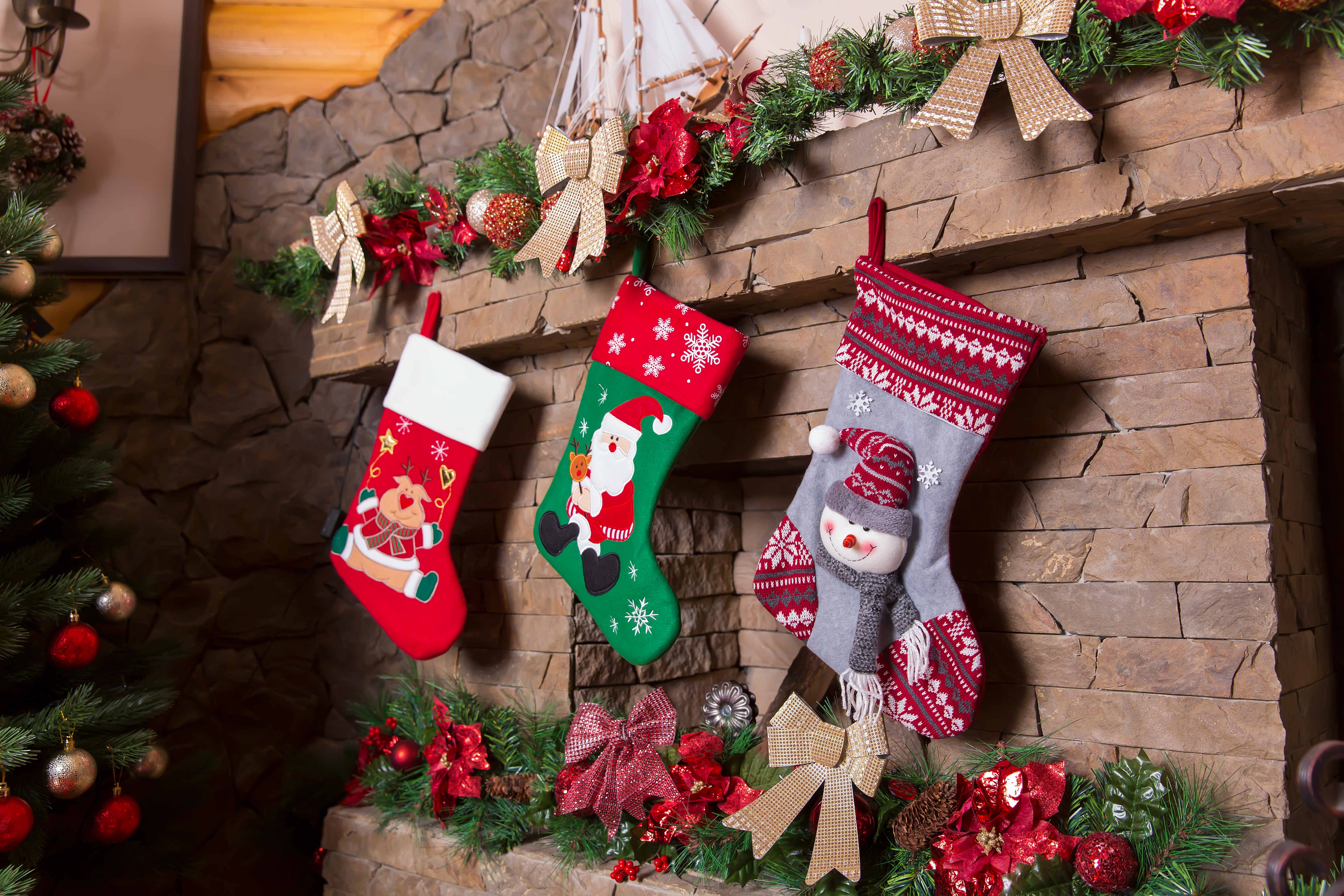 Christmas stockings hanging on a stone fireplace with festive garlands and bows, representing mom and MIL holiday decor. Christmas stockings hanging on a stone fireplace with festive garlands and bows, representing mom and MIL holiday decor.
