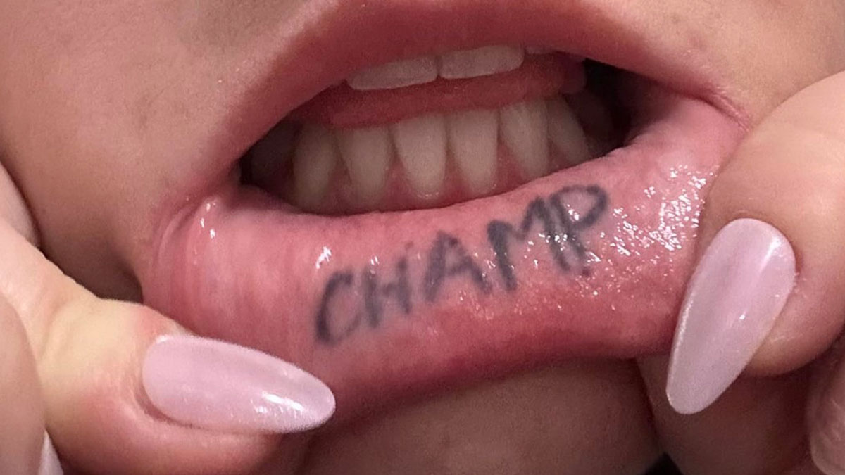 Close-up of a person's lip tattoo with word champ, highlighting strange tattoo artists refused to ink designs.