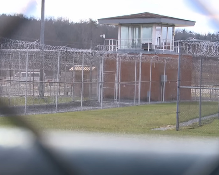 Prison facility with barbed wire fencing and watchtower representing capital punishment for stabbing and pentagram carving case. Prison facility with barbed wire fencing and watchtower representing capital punishment for stabbing and pentagram carving case.