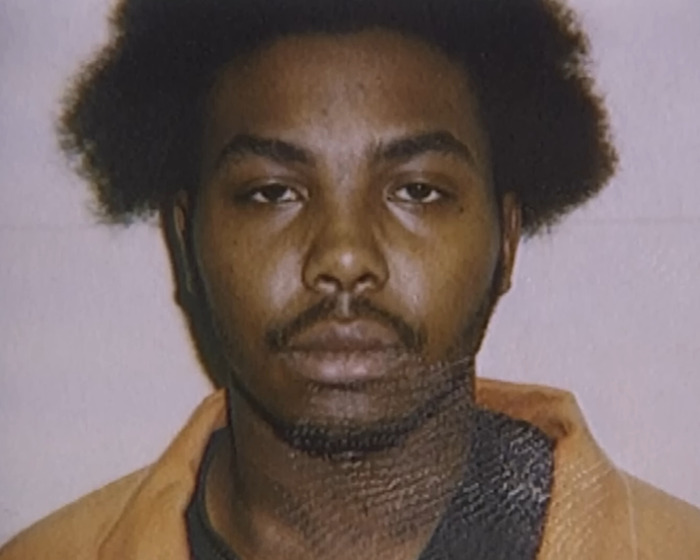 Mugshot of a man with afro hair wearing an orange prison jumpsuit related to stabbing and pentagram crime case. Mugshot of a man with afro hair wearing an orange prison jumpsuit related to stabbing and pentagram crime case.