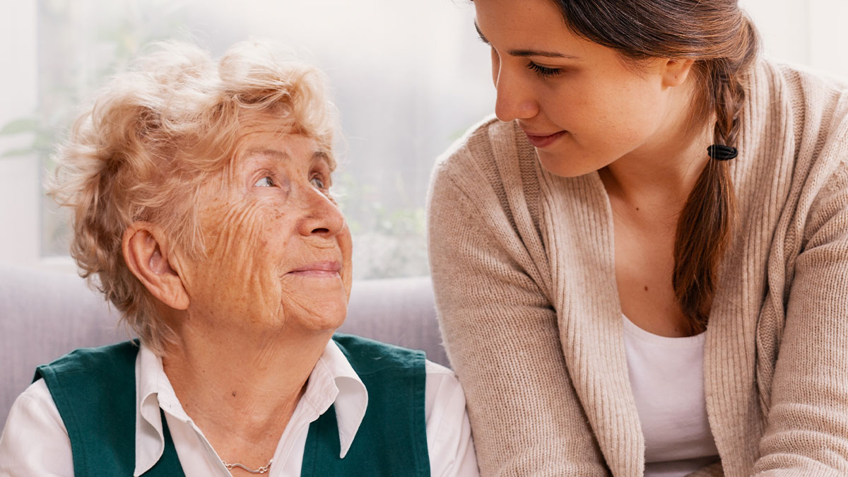 Elderly woman and younger woman sharing a tender moment, reflecting family dynamics during a Thanksgiving gathering.