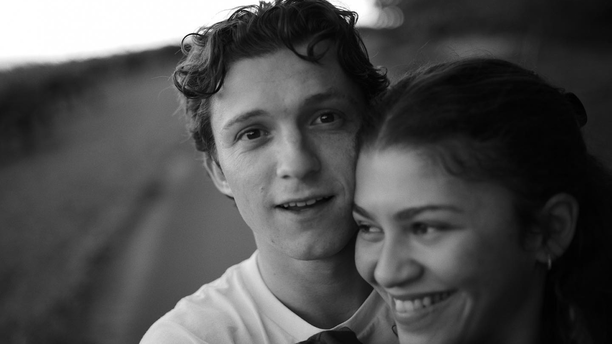 Young Hollywood power couple smiling together outdoors in a candid black and white portrait showing enduring connection.