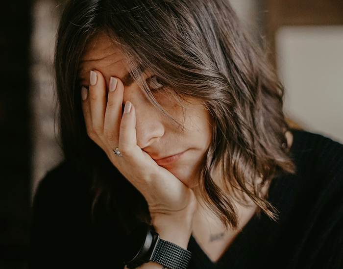 Woman looking frustrated and tired, representing the stress of being the bestie bank for a friend with multiple kids and dads. Woman looking frustrated and tired, representing the stress of being the bestie bank for a friend with multiple kids and dads.