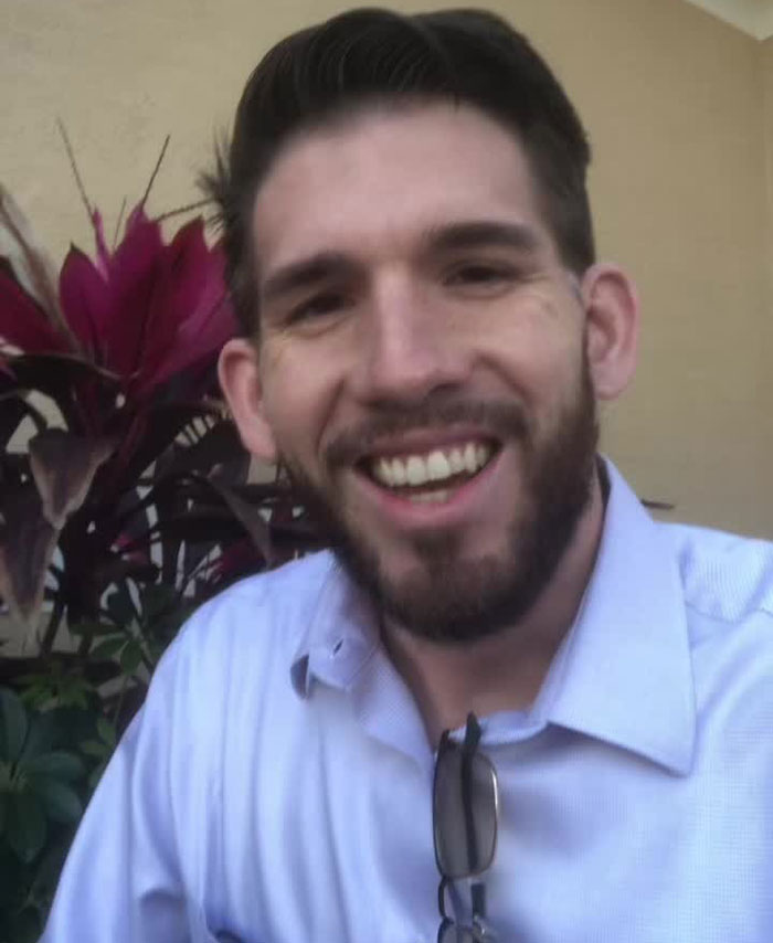 Smiling man with beard wearing a light blue shirt, representing Florida man in Starbucks tantrum over Pride flag incident.