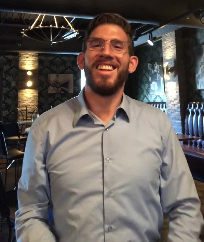 Man smiling in casual setting, related to Florida man arrested after tantrum at Starbucks over pride flag.