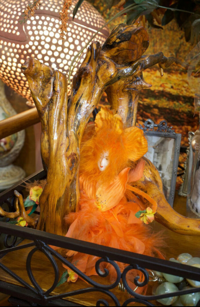Handcrafted orange doll surrounded by wooden branches and decorative flowers in a surprising Airbnb setting. Handcrafted orange doll surrounded by wooden branches and decorative flowers in a surprising Airbnb setting.