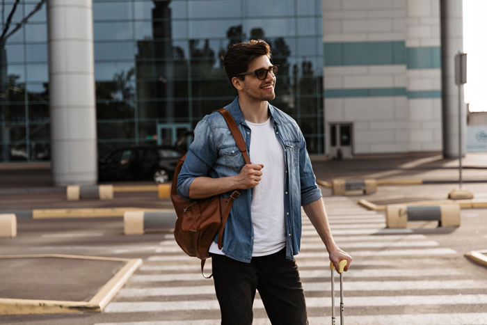 Young man with sunglasses and backpack standing outdoors with luggage, symbolizing surprise family visit during surgery planning. Young man with sunglasses and backpack standing outdoors with luggage, symbolizing surprise family visit during surgery planning.