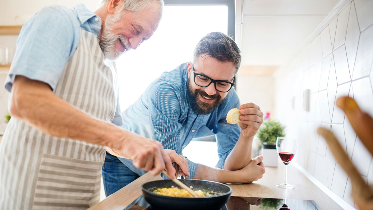 Two men cooking together in a bright kitchen, sharing kitchen cheats to cook smarter, not harder with chicken.