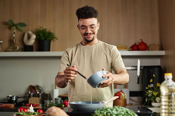 Man cooking in modern kitchen, symbolizing a woman realizing her ex might have been poisoning her health. Man cooking in modern kitchen, symbolizing a woman realizing her ex might have been poisoning her health.