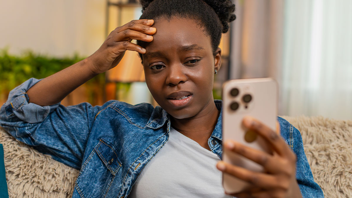 Young woman looking distressed while reading a phone message about open marriage and emotional relationship twist.