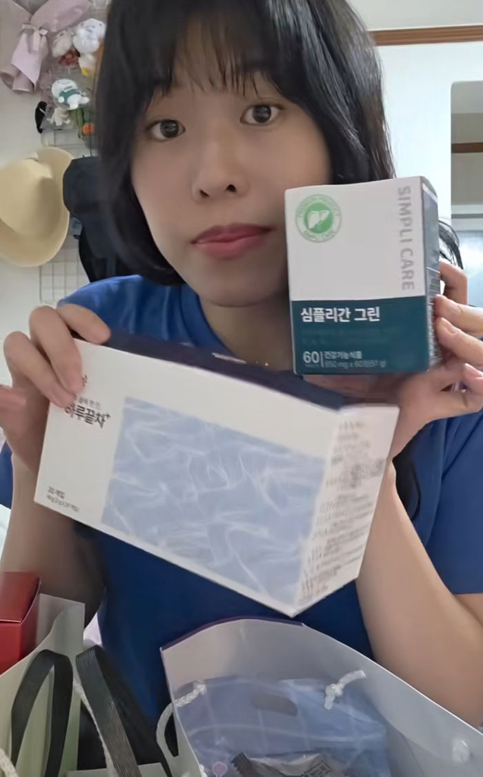 Woman showing gifts received while interviewing for jobs in Korea, surrounded by various product boxes and bags. Woman showing gifts received while interviewing for jobs in Korea, surrounded by various product boxes and bags.