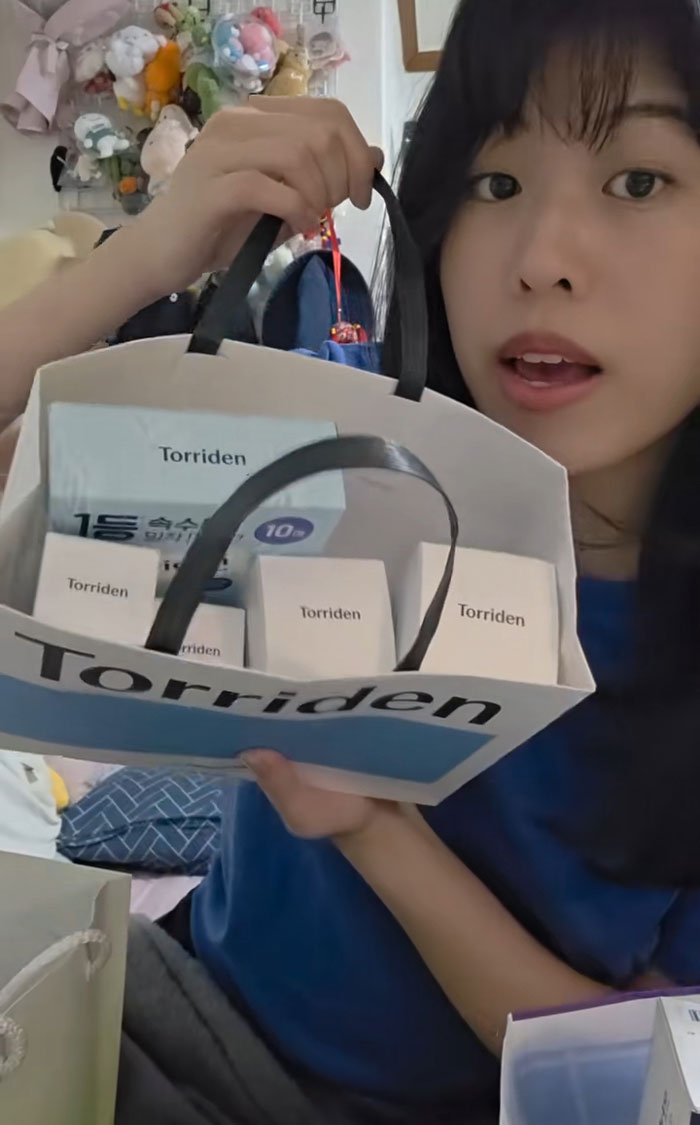 Woman holding a bag of gifts received while interviewing for jobs in Korea, showing excitement and surprise. Woman holding a bag of gifts received while interviewing for jobs in Korea, showing excitement and surprise.