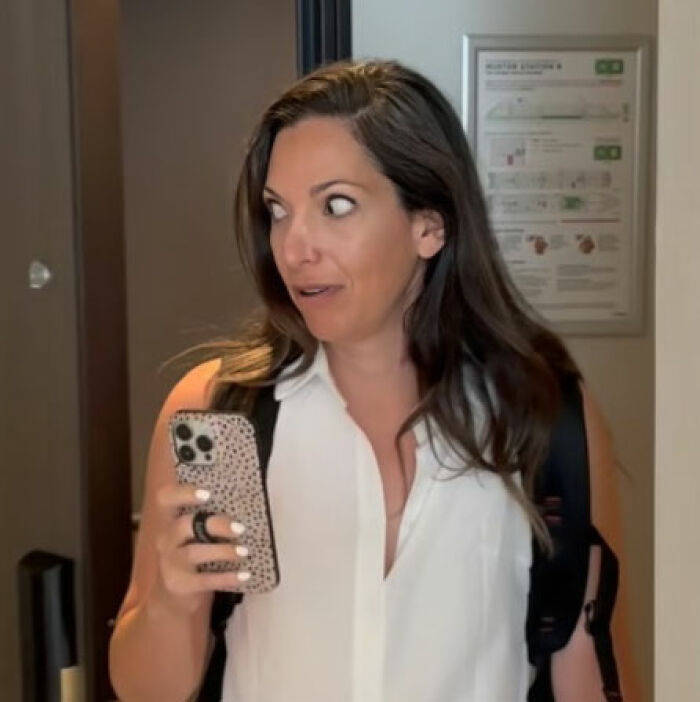 Woman holding phone with surprised expression after using Meta glasses to record vacation footage and regrets her mistake Woman holding phone with surprised expression after using Meta glasses to record vacation footage and regrets her mistake