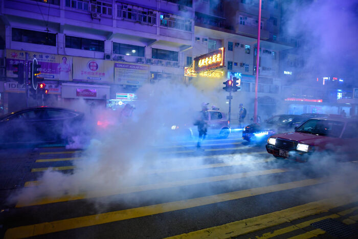 City street at night filled with thick smoke and blurred figures, illustrating a Halloween nightmare experience.