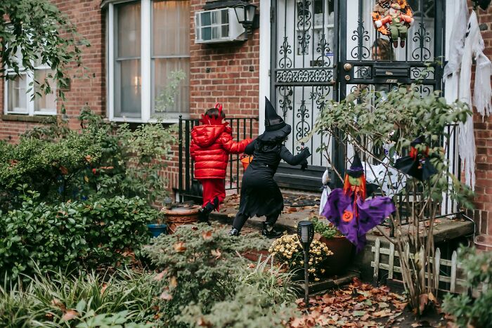 Two children in Halloween costumes approaching a decorated house, illustrating Halloween experiences turning fun into nightmare moments.