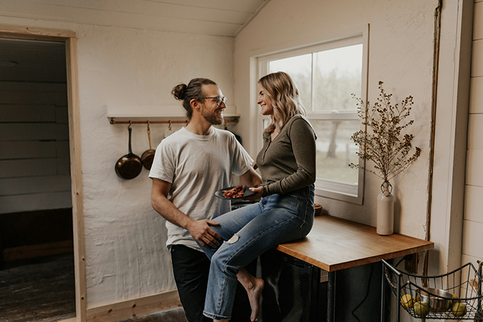 Young couple smiling in cozy kitchen, highlighting relationship trust and issues around rent and deception. Young couple smiling in cozy kitchen, highlighting relationship trust and issues around rent and deception.