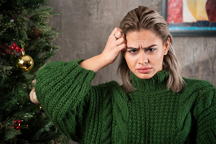 Woman in green sweater looking confused and frustrated, representing sister furious about dog photo prank gift. Woman in green sweater looking confused and frustrated, representing sister furious about dog photo prank gift.